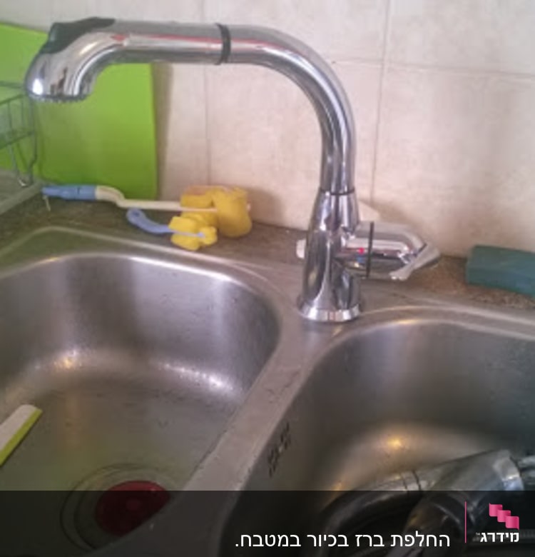 כיור מטבח עם ברז וכלי עבודה של אינסטלטור